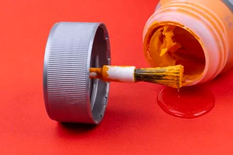 Orange do-it-yourself paint with brush and red background Stock Photos