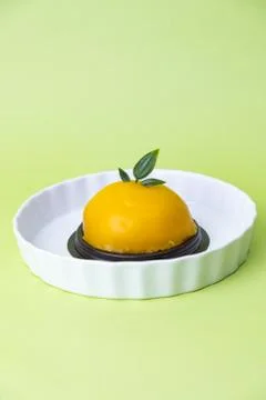 Orange dome cake. Set on green background. Stock Photos