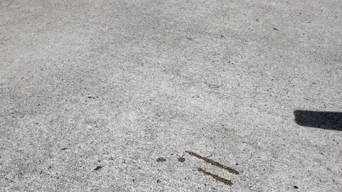 Orange double stick popsicle  drops onto a driveway in slow motion with copy Stock Footage 94340267