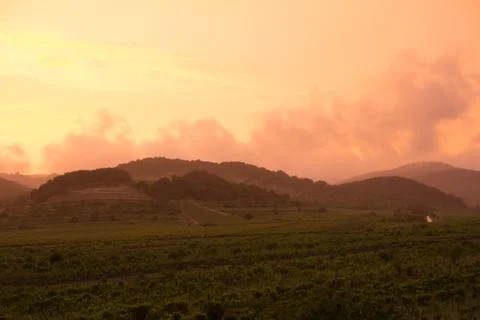 Orange dramatic sunset over hills Stock Photos