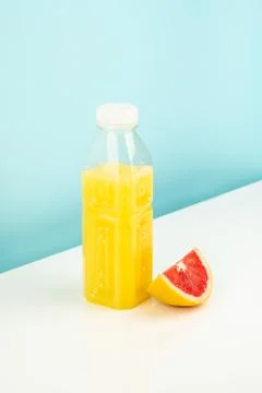 Orange drink and slice of grapefruit on white and blue background Stock Photos