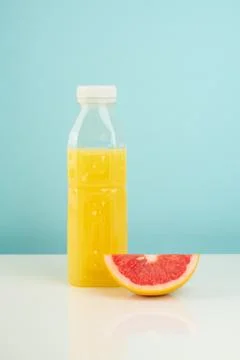 Orange drink and slice of grapefruit on white and blue background Stock Photos