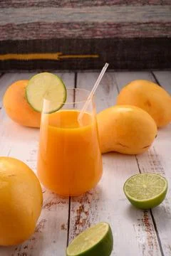 Orange drink closeup with lime slice on white vintage wooden desktop with man Stock Photos
