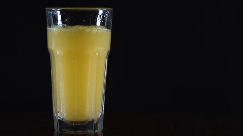 Orange drink in a glass. The tablet is dissolved in water. Video stock 124659569
