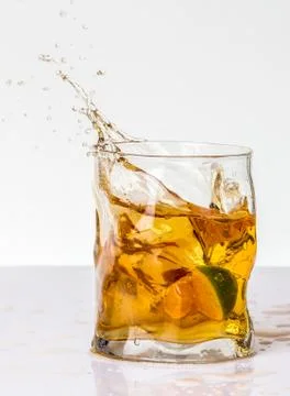 Orange drink with lime splash Stock Photos