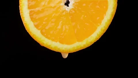 Orange with dripping clear juice on black background 스톡 동영상 248782714