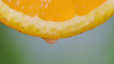 Orange with dripping clear juice on green background Vídeos de archivo 248786789