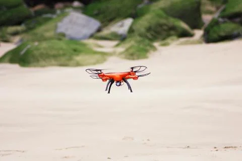 Orange drone flying on the beach Stock Photos