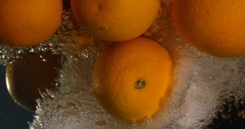 Orange Drops Under Water on Black Background. Fresh Orange Fruit Plunging And Video stock 96545281