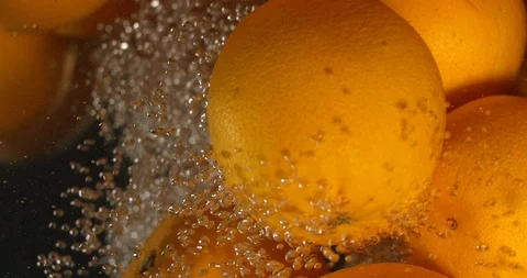 Orange Drops Under Water on Black Background. Fresh Orange Fruit Plunging And Stock Footage 96545453