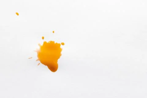 Orange drops on white paper surface. Stock Photos