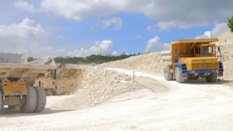 An orange dump truck is driving through a sand quarry, mining equipment. Mining Stock-Footage 156384409
