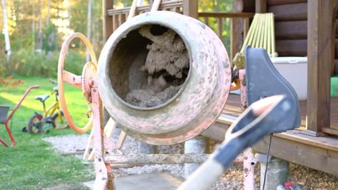 An orange electric concrete mixer machine rotating and mixing Vidéo 342234687