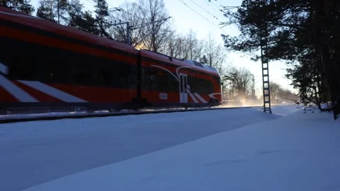 Orange Electric Train Crossing Snowy Tracks in Golden Winter Sun Stock Footage 332406491