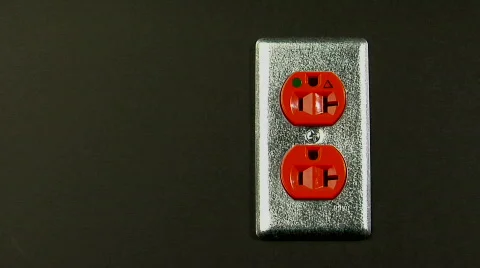 An orange electrical outlet sits in a wall. Stock Footage 554974
