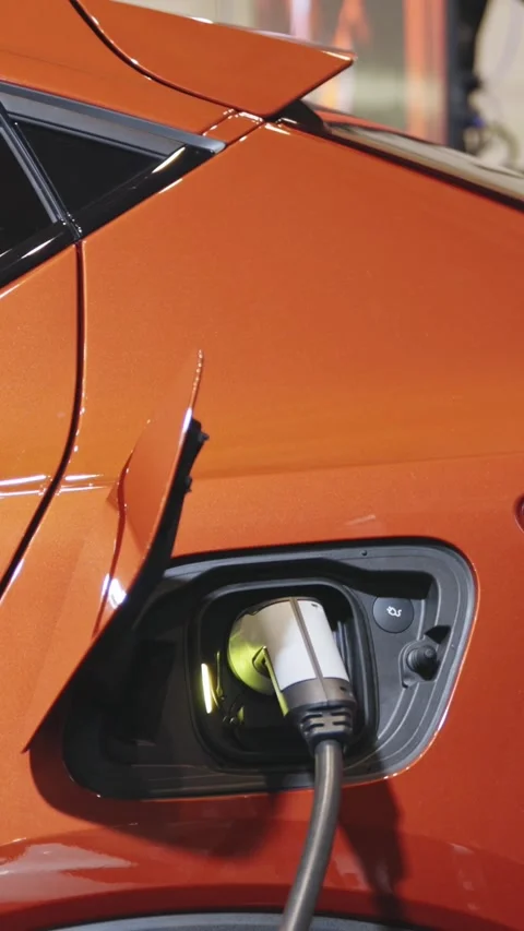 Orange electro car on charge at the charging station Stock Footage 328452376