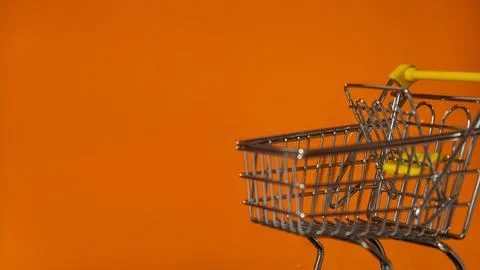 Orange empty screen of computer laptop with shopping cart. E-commerce Online Stock Photos