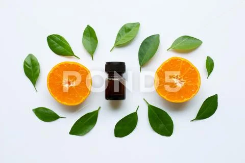 Orange essential oil with fresh orange citrus fruit and green leaves Stock Photos