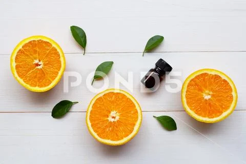 Orange essential oil with fresh orange citrus fruit and green leaves on white Stock Photos