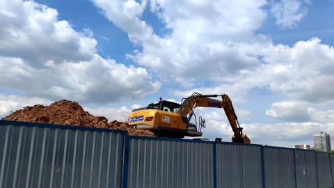 Orange excavator on construction site Stock Footage 257958144