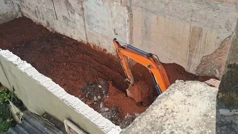 Orange excavator digging deep soil in motion video construction site Video stock 339374454