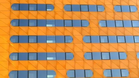 Orange Facade of building with pattern of oval shaped mirror windows. Modern arc Stock Photos