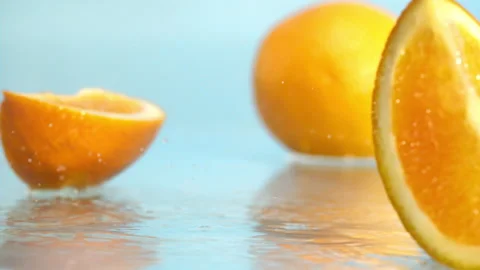 Orange fall into the water on blue background Super slow-mo 1000 fps Stock Footage 276732248