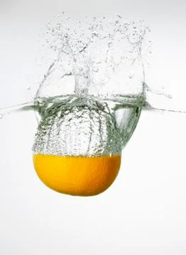 Orange falling into water Stock-Fotos