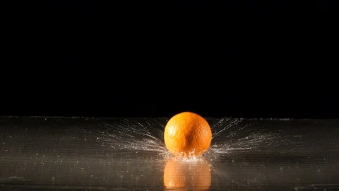 Orange falling on wet surface in slow motion Stock Footage 88801494