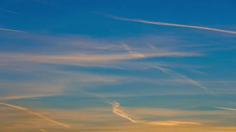 Orange feather clouds and plane trails at sunrise - timelapse Stock Footage 165453650