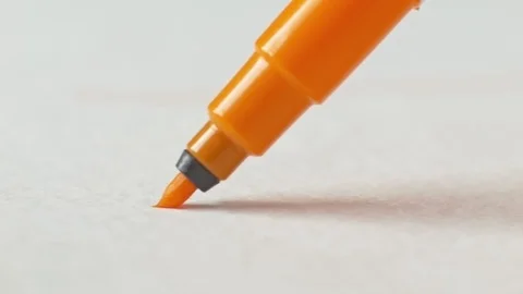 Orange felt-tip pen writes line on paper. Macro Stock-Footage 97592423