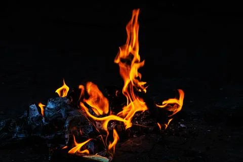Orange fire flames on dark background Stock Photos