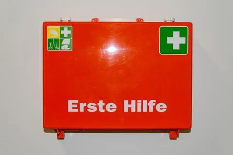 Orange first aid case labeled in German language First Help hanging on the wa Stock Photos