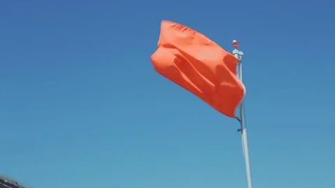 Orange flag blowing in the wind. Stock Footage 77525158