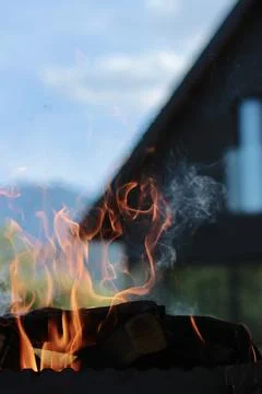 Orange flame of fire on the background of the house. Stock Photos