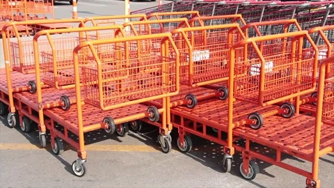 Orange flatbed shopping carts buggies dollies trollies inside each other outside Stock Footage 251361118