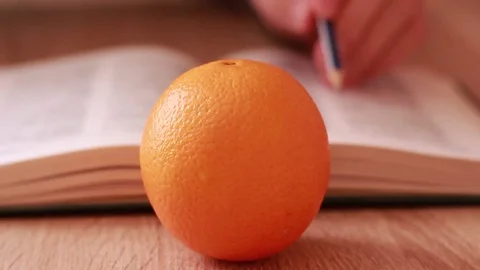 Orange in front of the opened book Stock-Footage 84676041