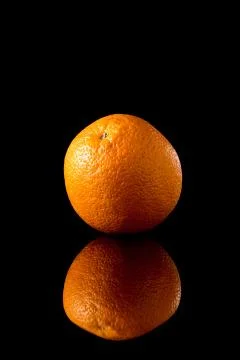 Orange fruit on a black reflective background Stock Photos