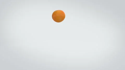 Orange fruit bouncing playfully and then coming to a stand still center screen Stock Footage 57815027
