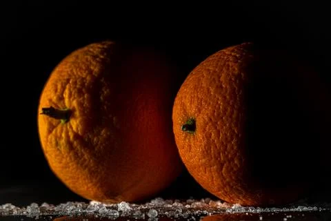 Orange fruit detail with shiny black table and white salt Stock Photos
