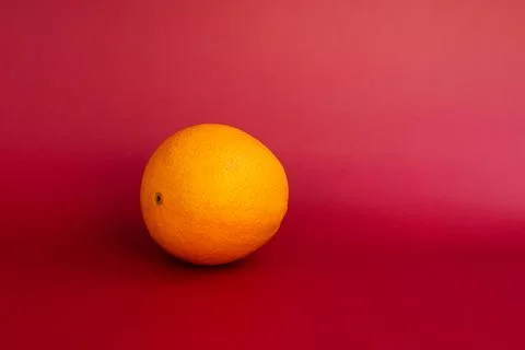 Orange fruit on a red background. Stock Photos