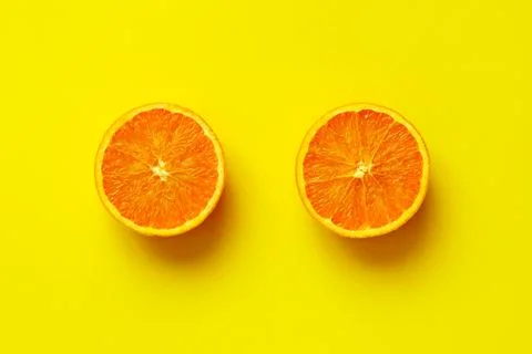 Orange fruit sliced in half isolate on yellow background Stock Photos