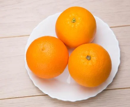 Orange fruits plate on wooden table background Stock Photos