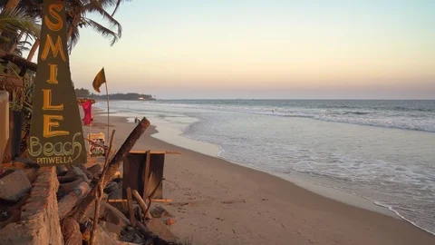 Orange glow sunset scene across tropical sandy beach Stock Footage 107879102