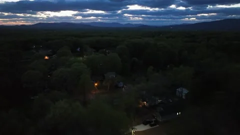 Orange glowing lantern between green trees at dusk. American suburb Stock Footage 307639747