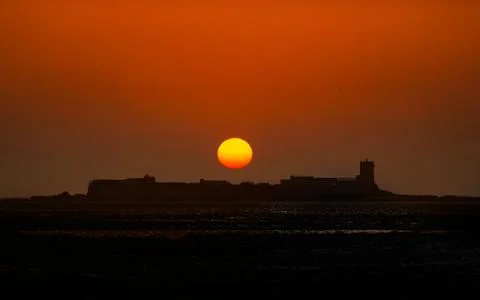 Orange glowing setting sun over   buildings at the horizon Fotos de archivo