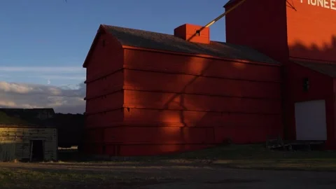 An orange grain elevator stands tall in fields of green cereal crops, with Stock Footage 170749460