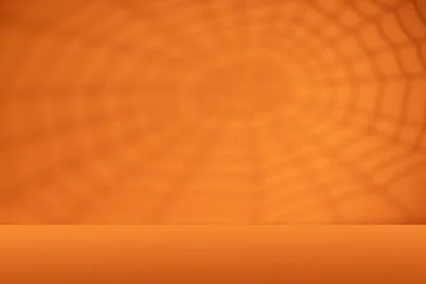 Orange Halloween background with spiderweb shadow and empty tabletop for sp.. Stock Photos