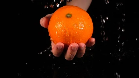Orange in hands with water drop 库存影片 88615802