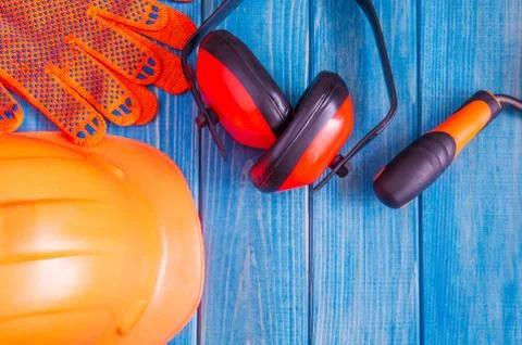 Orange hard hat and tool on wooden vintage blue boards Stock Photos
